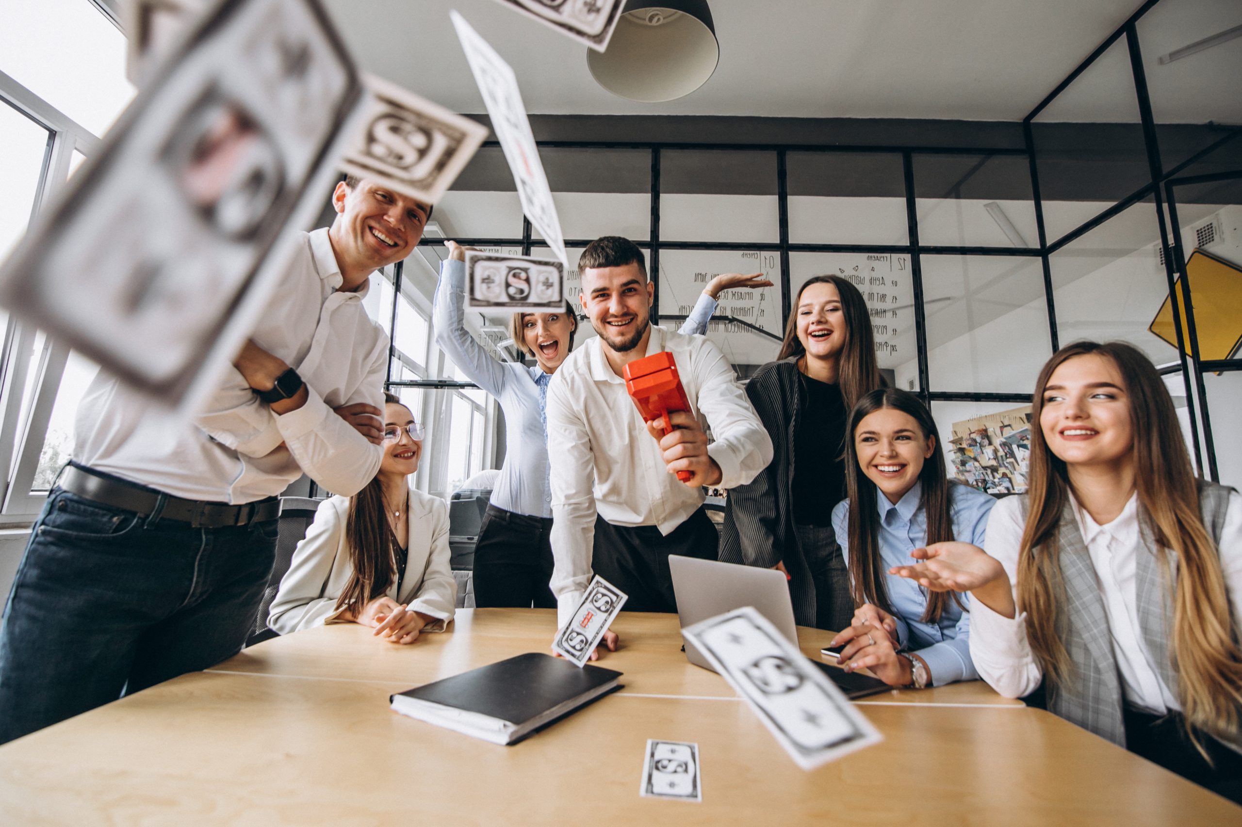 Group of people throwing money in an office
